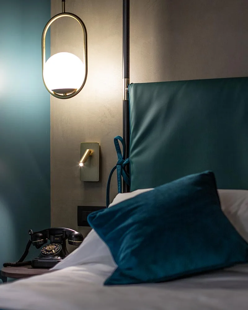 hotel arredo camera letto testata colori dettagli illuminazione