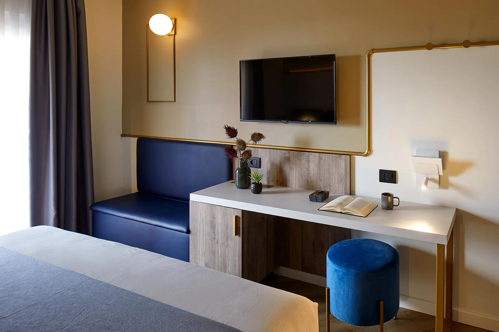 arredamento hotel camera materiali colori fronte letto illuminazione