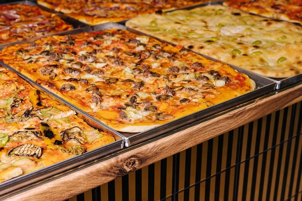 Pale di pizza sul bancone di una pizzeria focacceria